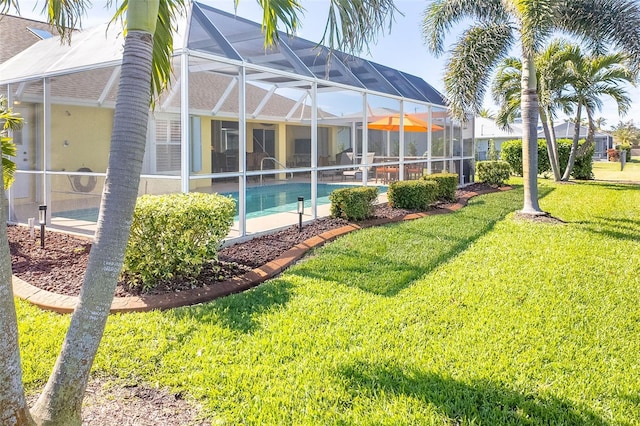 view of pool featuring a yard and glass enclosure