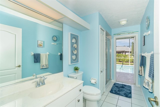 bathroom featuring vanity, tile patterned floors, a textured ceiling, and toilet