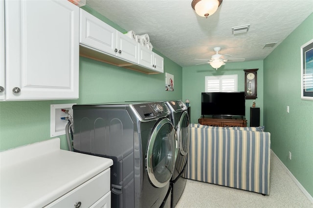 laundry room featuring cabinets, independent washer and dryer, ceiling fan, and a textured ceiling