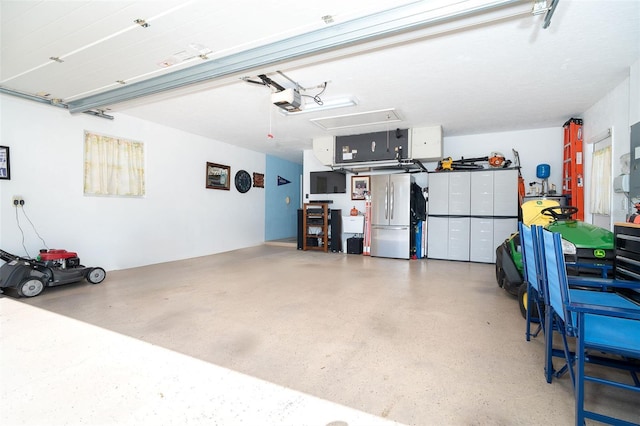 garage with a garage door opener and stainless steel fridge