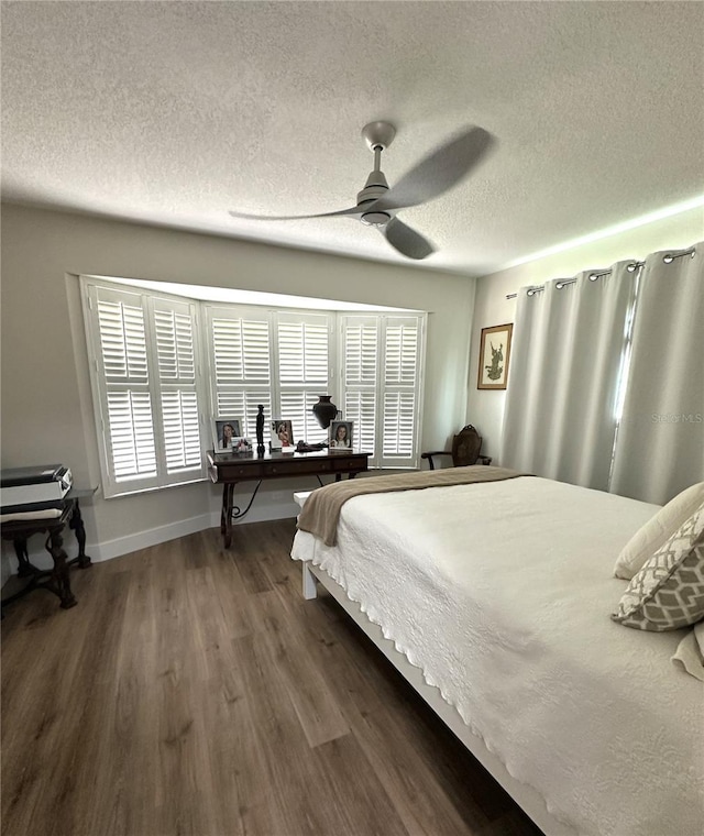 bedroom with dark hardwood / wood-style floors, a textured ceiling, and ceiling fan