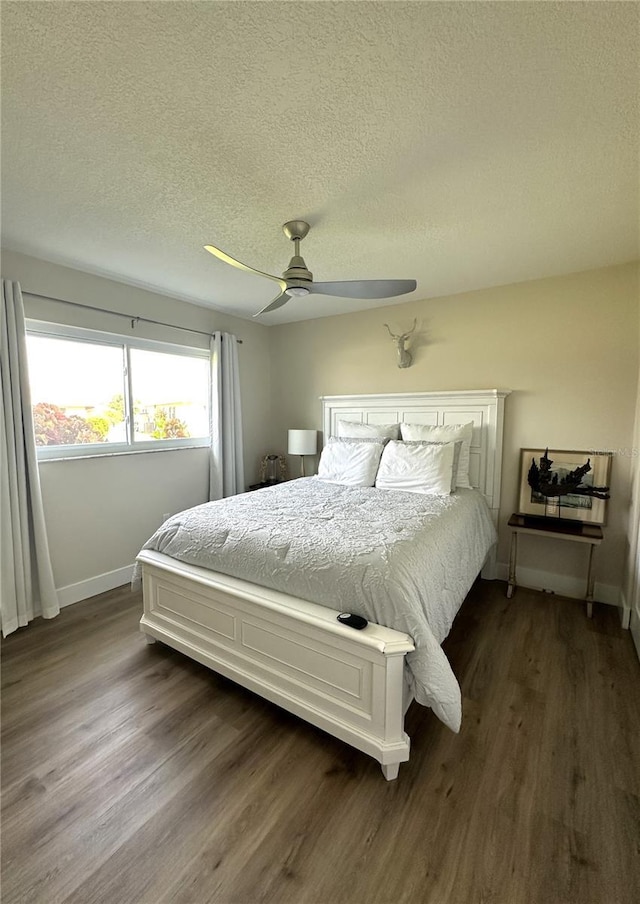 bedroom featuring dark hardwood / wood-style flooring, a textured ceiling, and ceiling fan