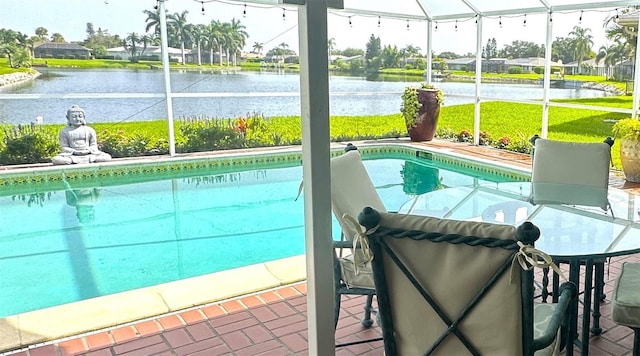 view of swimming pool with a water view and glass enclosure