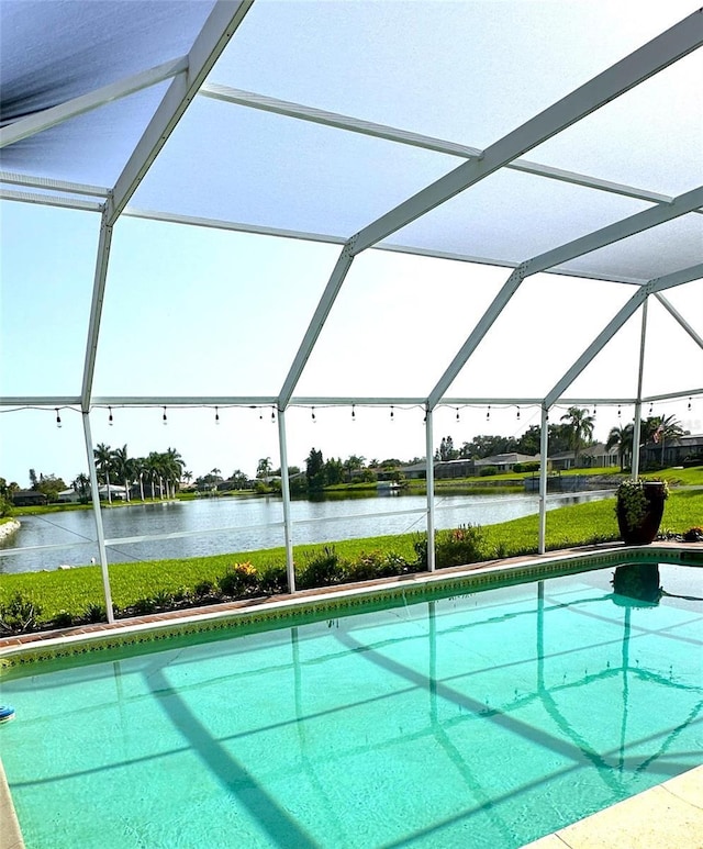 view of pool with a water view and glass enclosure