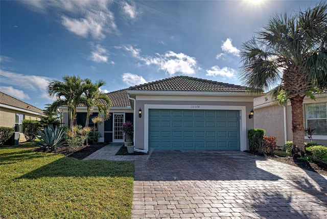 mediterranean / spanish house featuring a garage and a front yard