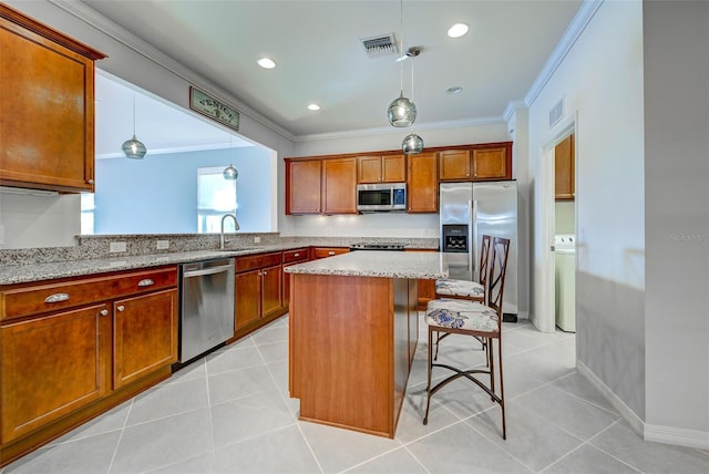 kitchen featuring a kitchen island, washer / clothes dryer, sink, a breakfast bar area, and stainless steel appliances