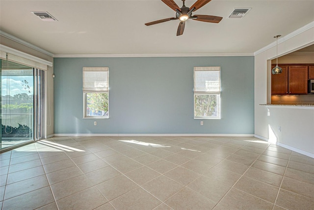 empty room featuring light tile patterned flooring, a healthy amount of sunlight, and crown molding