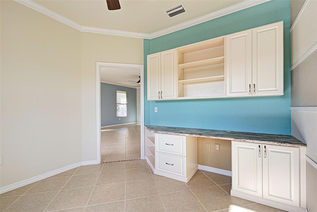 kitchen featuring crown molding, built in desk, ceiling fan, and light tile patterned flooring