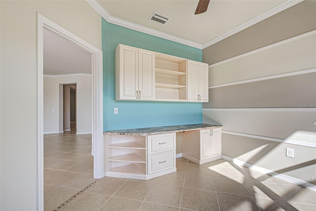 unfurnished office featuring light tile patterned floors, built in desk, ornamental molding, and ceiling fan