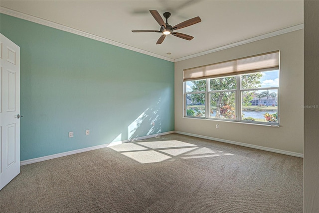 carpeted empty room with ornamental molding, ceiling fan, and a water view