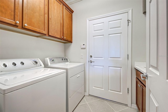 laundry room featuring light tile patterned floors, washer and clothes dryer, and cabinets