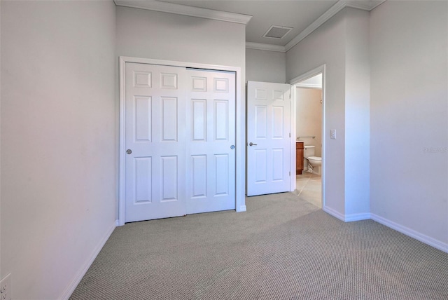 unfurnished bedroom featuring crown molding, light colored carpet, and a closet