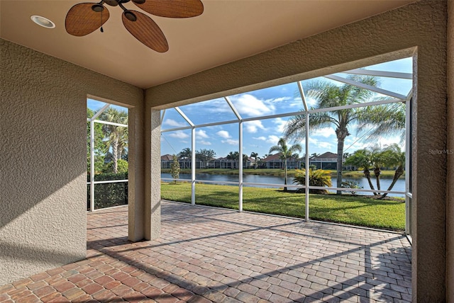 unfurnished sunroom with a water view, ceiling fan, and a healthy amount of sunlight