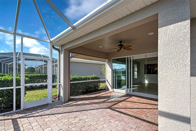 unfurnished sunroom with ceiling fan