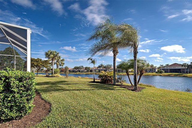 view of yard with a water view and glass enclosure