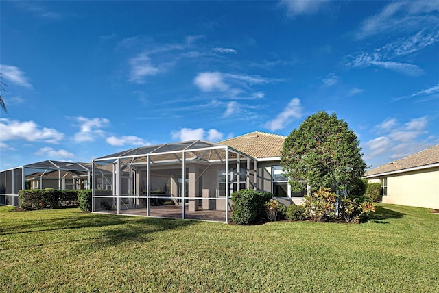 rear view of house featuring a patio, a lanai, and a yard