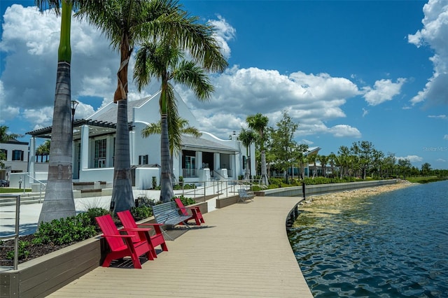 back of property with a water view and a pergola