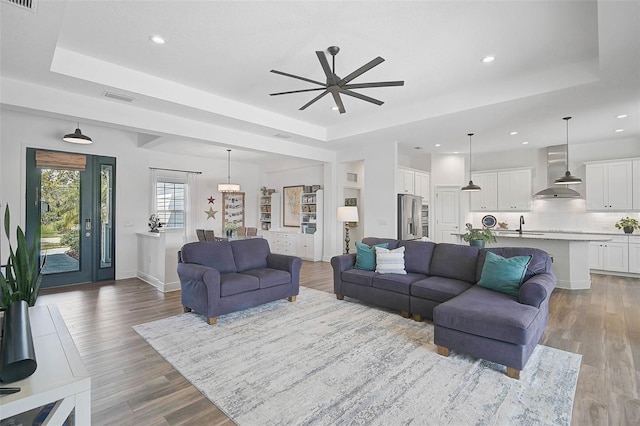 living room featuring hardwood / wood-style flooring and a tray ceiling