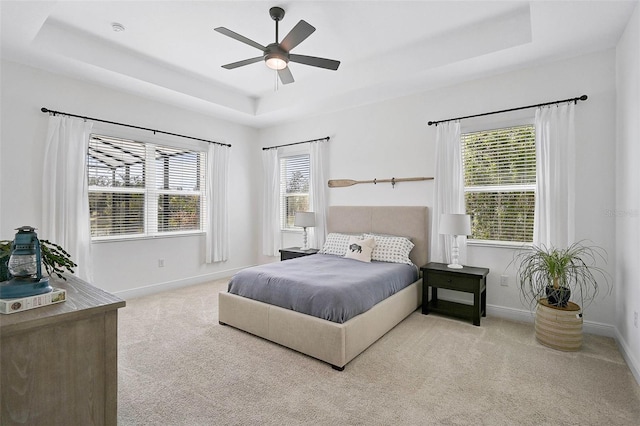 bedroom featuring ceiling fan, carpet flooring, and a raised ceiling