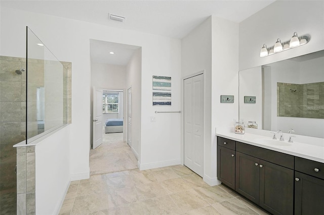 bathroom with vanity and a tile shower