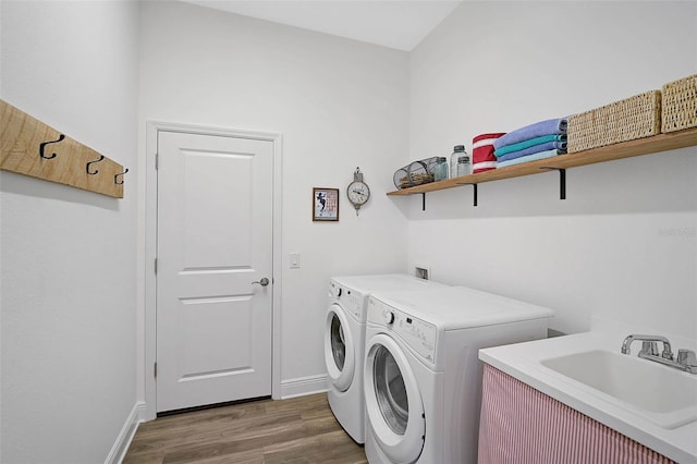 laundry room with sink, washing machine and dryer, and dark hardwood / wood-style floors