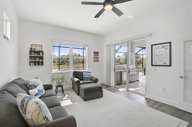 living room featuring ceiling fan, light wood-type flooring, and a wealth of natural light