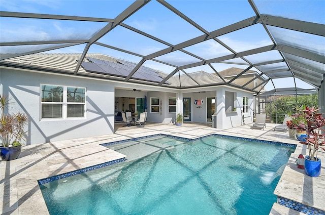 view of pool with a lanai, a patio area, and ceiling fan