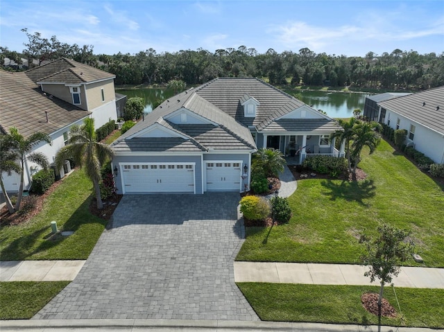 view of front of property with a garage, a front lawn, and a water view