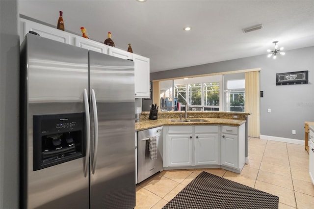 kitchen with stone countertops, white cabinetry, sink, light tile patterned floors, and stainless steel appliances