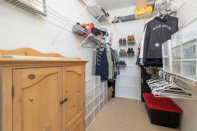 walk in closet with light colored carpet