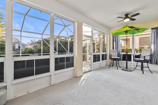 unfurnished sunroom featuring ceiling fan