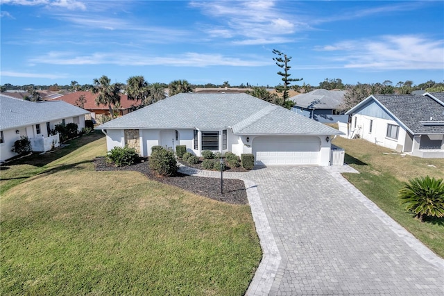 single story home featuring a garage, a front yard, and decorative driveway