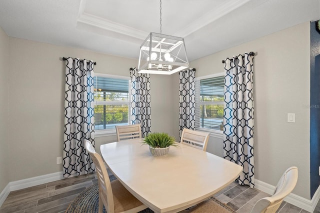 dining space with a raised ceiling and an inviting chandelier