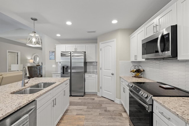 kitchen featuring sink, white cabinetry, hanging light fixtures, stainless steel appliances, and light stone countertops