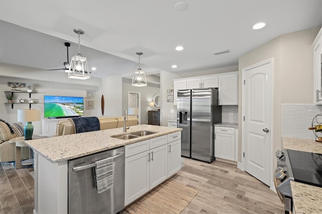 kitchen featuring pendant lighting, sink, white cabinets, and appliances with stainless steel finishes