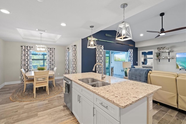 kitchen featuring hanging light fixtures, dishwasher, sink, and white cabinets