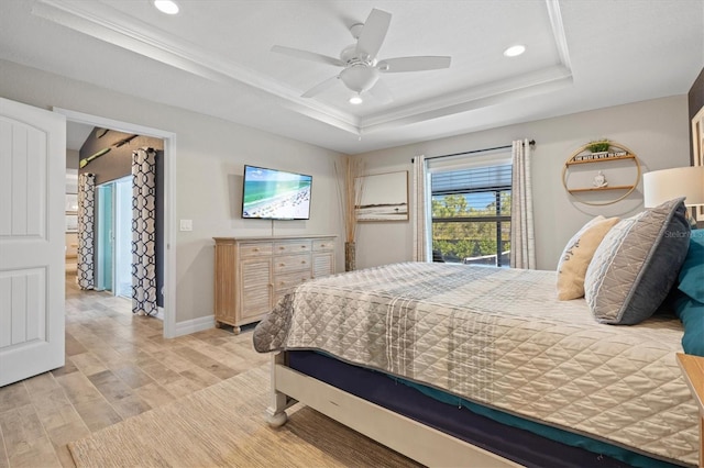 bedroom with ceiling fan, ornamental molding, a tray ceiling, and light wood-type flooring