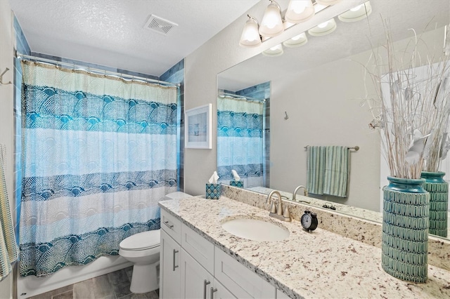 bathroom with vanity, toilet, and a textured ceiling