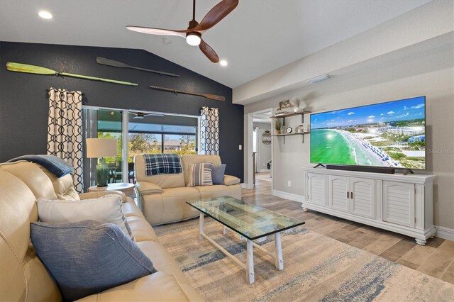 living room featuring ceiling fan, vaulted ceiling, and light hardwood / wood-style floors