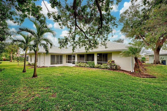 back of property featuring a sunroom and a yard