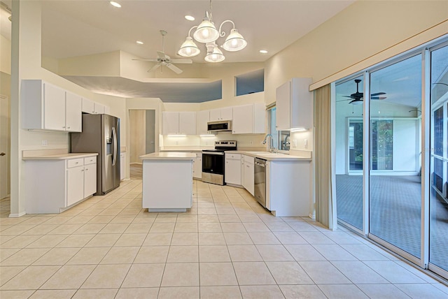 kitchen featuring appliances with stainless steel finishes, a center island, ceiling fan with notable chandelier, and white cabinets