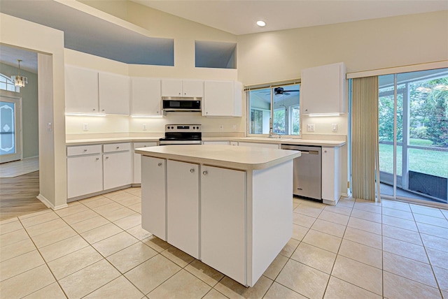 kitchen featuring white cabinetry, appliances with stainless steel finishes, a center island, and plenty of natural light