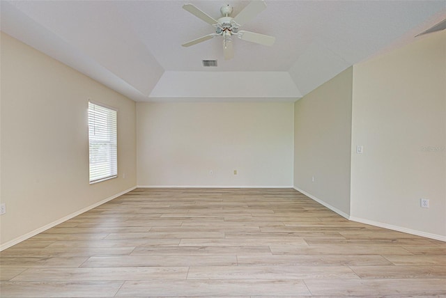 unfurnished room with ceiling fan, a raised ceiling, and light hardwood / wood-style flooring