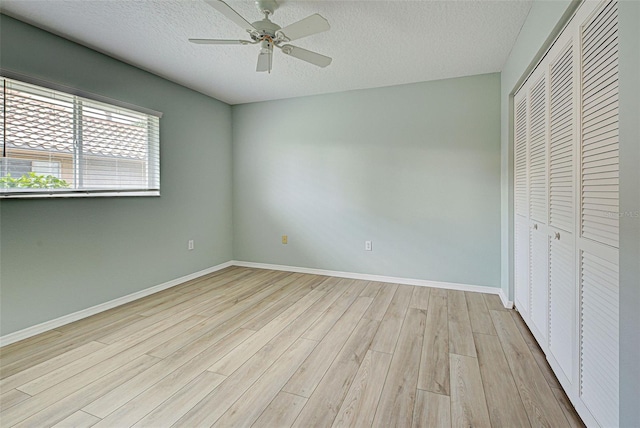 unfurnished bedroom with a closet, a textured ceiling, ceiling fan, and light hardwood / wood-style floors