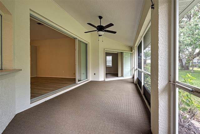 unfurnished sunroom featuring ceiling fan and vaulted ceiling