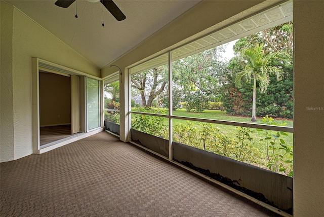 unfurnished sunroom with ceiling fan and vaulted ceiling