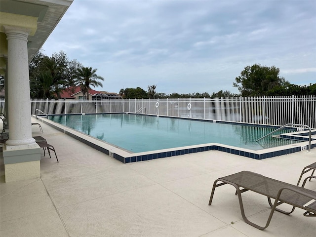 view of pool with a water view and a patio