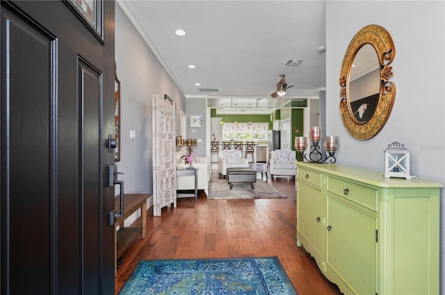 foyer entrance with crown molding, dark hardwood / wood-style floors, ceiling fan, and a textured ceiling