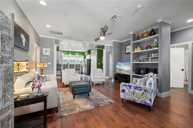 living room with ceiling fan, dark wood-type flooring, ornamental molding, and a textured ceiling