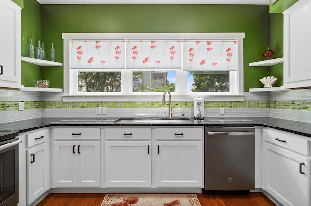 kitchen with white cabinetry, sink, dark stone countertops, backsplash, and stainless steel appliances